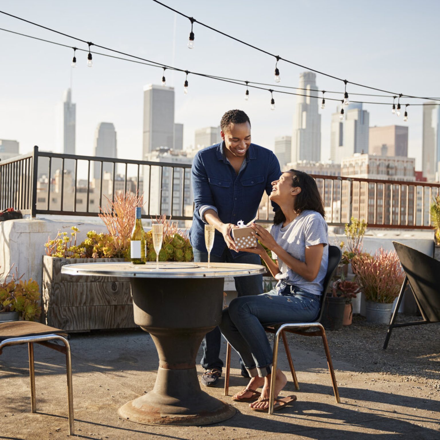 rsz man giving woman gift as they celebrate on rooftop 2024 10 19 04 32 08 utc 1536x1536